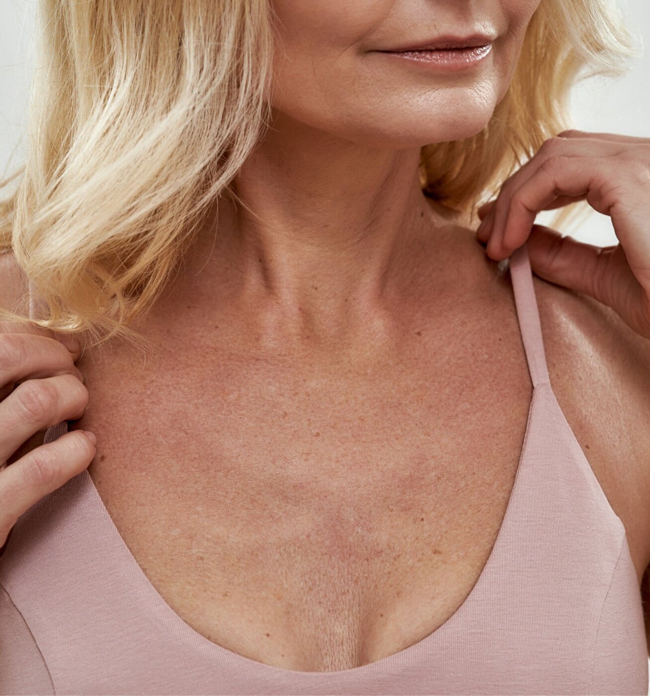 blond woman with a pink bra top and a necklace on her neck