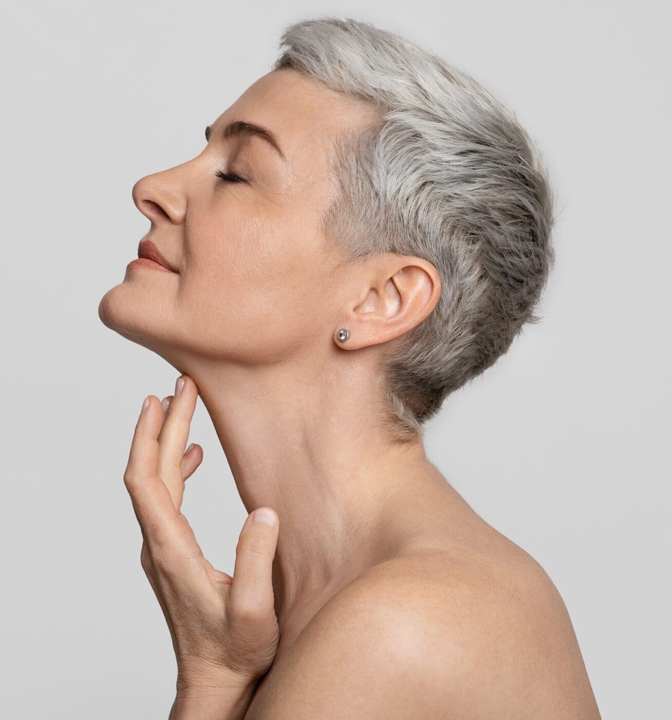 there is a woman with a short gray hair and a piercing on her ear