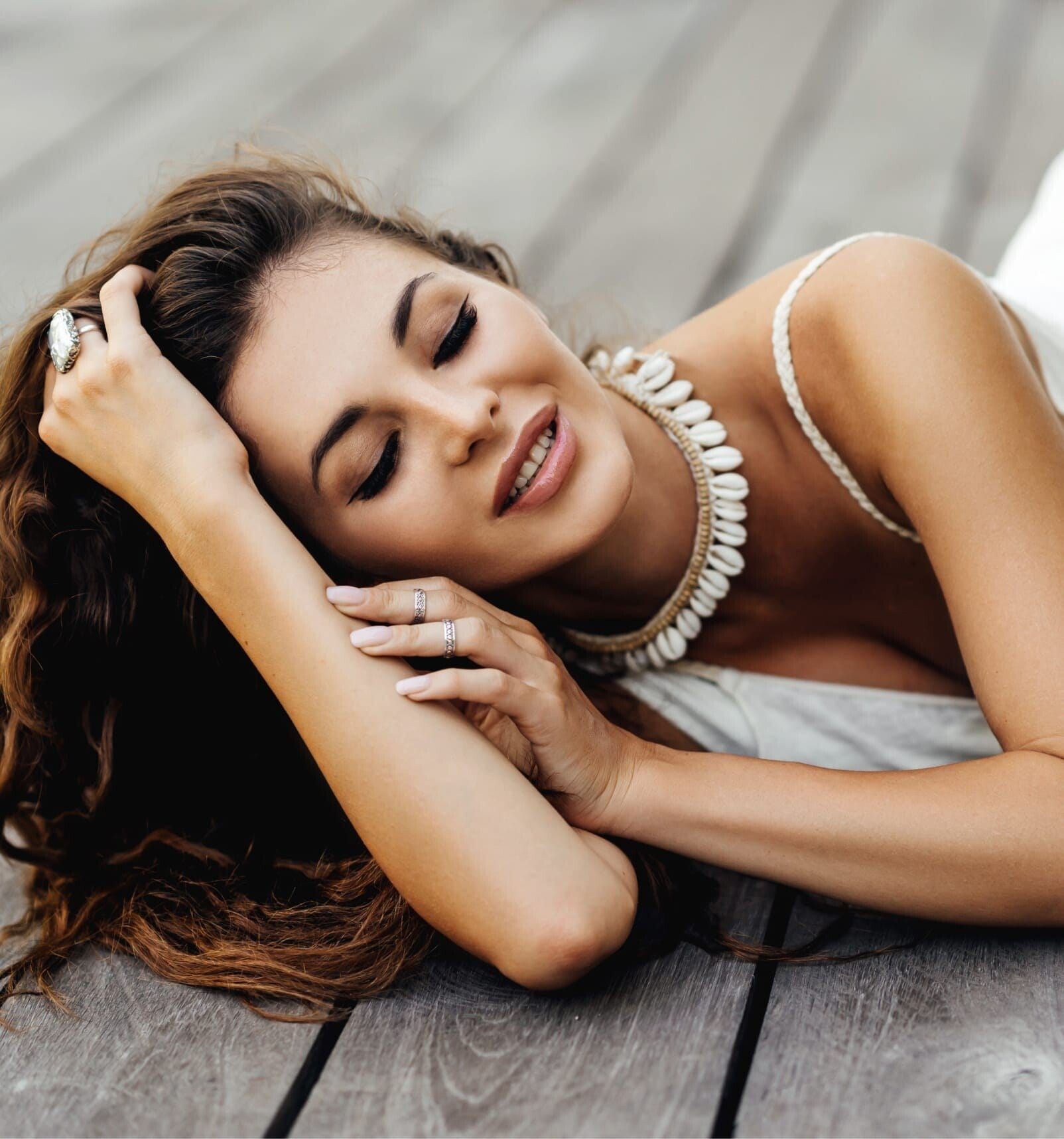 woman laying on a wooden floor with her eyes closed