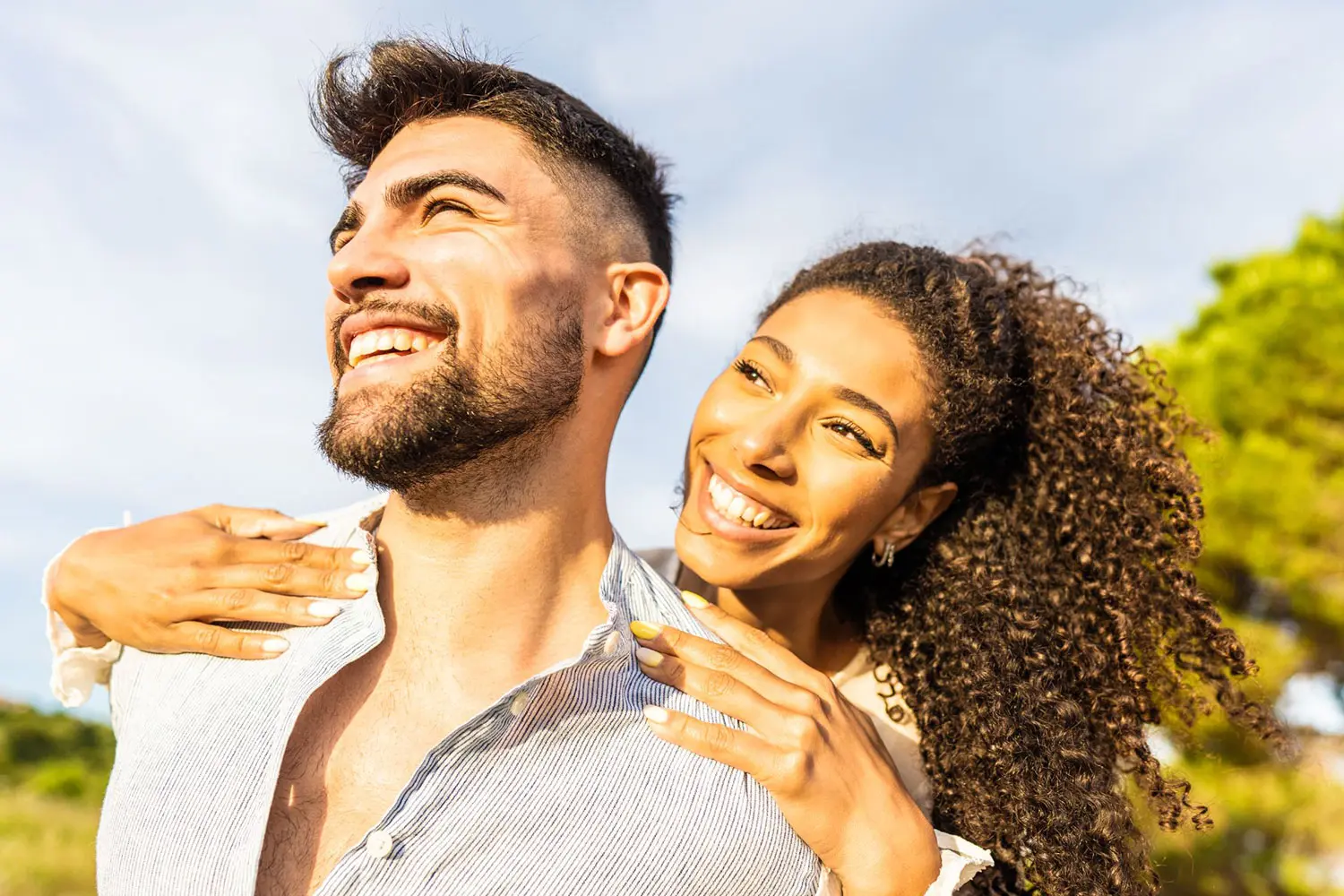 A man and woman smiling and standing close to each other