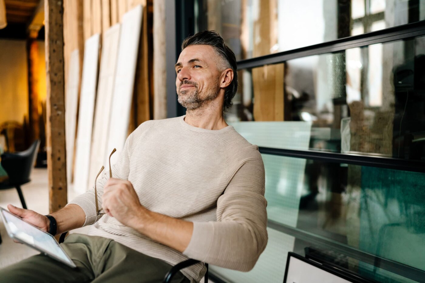 Man looking up and smiling while reading an ebook