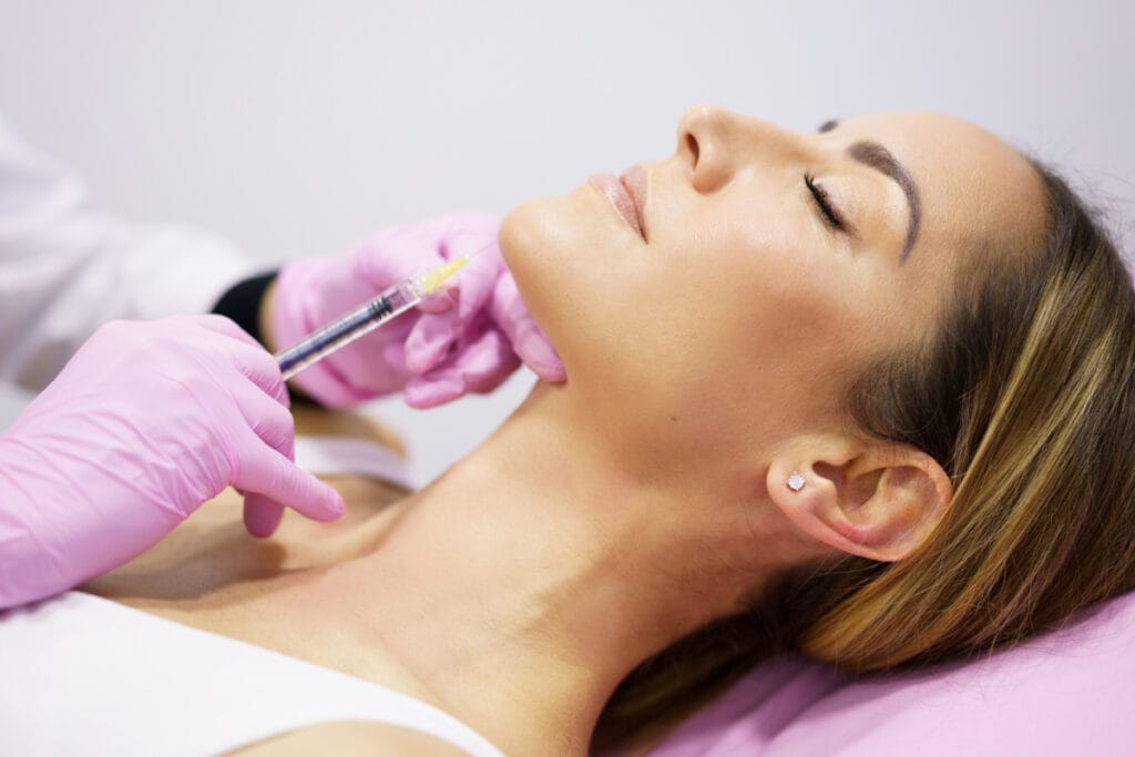Woman getting chin filler injections